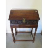 An 18th century and later carved oak sloping front box on stand with three internal drawers - Height