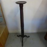 A carved mahogany torchere - Height 128cm