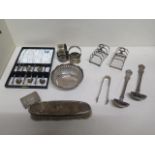 A collection of silver items to include a pair of small toast/letter racks, four serviette rings,