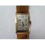 A 9ct yellow gold gents manual wind wristwatch on a leather strap - 23mm case - running, hands