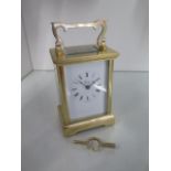 A brass carriage clock the dial signed Henley - Height 15cm with handle up - in good condition,