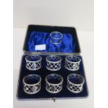 A boxed set of six silver napkin rings - no engraving and a single napkin ring - total weight approx