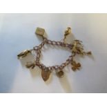 A 9ct yellow gold charm bracelet with eight charms - approx weight 36 grams