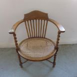 A beechwood barleytwist armchair with a cane seat - Height 78cm