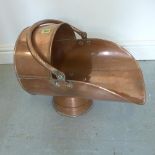 A copper helmet coal scuttle