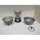 Three Eastern white metal embossed bowls, one on a wooden stand, one with broken base the other on a