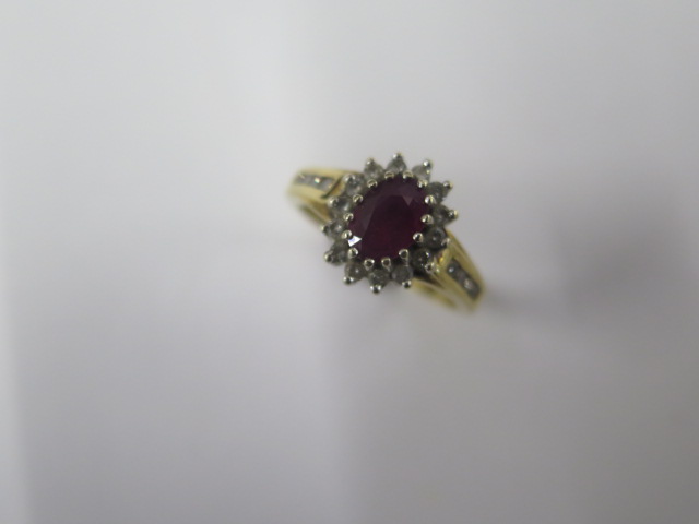 A hallmarked 18ct yellow gold diamond ring with a central red stone - ring size M - approx weight