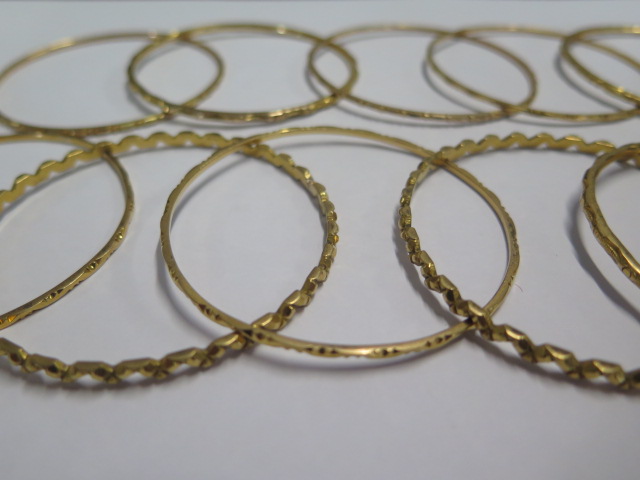 Eleven yellow metal bangles - surface test to approx 18ct gold - 6.2cm external diameter - total - Image 3 of 4