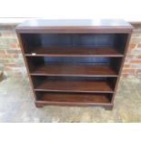 An Edwardian mahogany open bookcase with three adjustable shelves, blind fretwork frieze on shaped