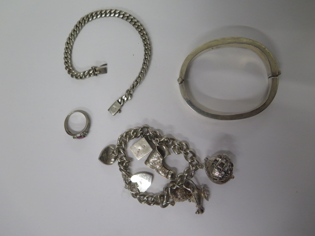 A hallmarked silver charm bracelet, another bracelet, bangle and ring all marked 925 - total