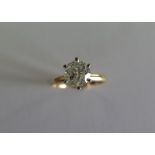 A yellow gold and white metal diamond solitaire ring with a round brilliant cut diamond approx