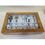 A collection of 12 assorted watches in an Axis show case