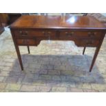 A 20th century reproduction mahogany desk with four frieze drawers on tapering legs - Height 80cm