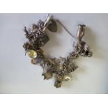 A silver/white metal charm bracelet - approx weight 76 grams