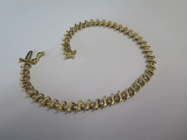 A 14ct yellow gold diamond line set tennis bracelet set with 15 diamonds - total weight approx 7.3