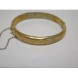 A hallmarked 9ct yellow gold bangle - 5.3cm x 5.5cm external - approx weight 7.2 grams - some