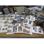 A large collection of Victorian and later postcards in over 70 small folders and albums including