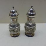 A pair of embossed silver sifters - Height 11.5cm - approx weight 3.4 troy oz - both good