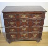 An 18th century oak chest with four geometric drawers raised on bun feet - Width 96cm x Depth 55cm x