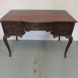 A late 19th/early 20th century mahogany writing desk with a leather inset top over five drawers -