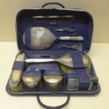 A Mappin and Webb blue leather travel dressing case with silver back, two brushes, mirror, comb