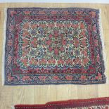 A small hand knotted woollen rug with a cream field - 95cm x 75cm - generally good