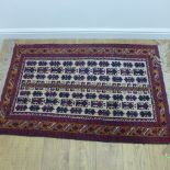 A small hand knotted woollen rug with a cream field - 160cm x 92cm - some small wear to fringes