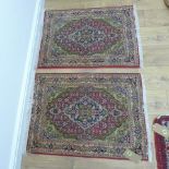 A pair of small hand knotted woollen rug with red fields - 90cm x 64cm - generally good