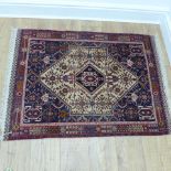 A small hand knotted woollen rug with a cream field - 128cm x 90cm - in good condition