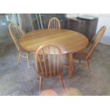 An Ercol drop leaf dining table 140cm x 127cm - with four matching chairs