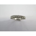 A diamond set half hoop eternity ring, the white shank and shoulders to 10 brilliant cut diamonds in