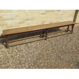A late 19th/20th century oak college bench on six turned legs - Length 256cm x Height 49cm