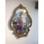 An ornate gilt wall mirror - Height 80cm x 56cm