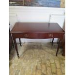 A Victorian mahogany side table with two frieze drawers, turned legs and casters - in polished