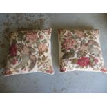 A pair of feather filled needlepoint cushions
