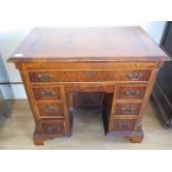 A yew wood desk with a pull out writing slide, eight drawers - Width 86cm x Height 78cm x Depth 55cm