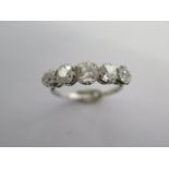 A five stone diamond set half hoop ring, the white shank (possibly platinum) and chenier shoulders