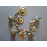 A 14ct yellow gold charm bracelet with seven charms set with semi precious stones - total weight