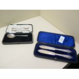 A boxed pair of silver butter knives, a silver spoon and a pair of silver pickle forks - total