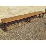 A late 19th/20th century oak college bench on six turned legs - Length 256cm x Height 49cm