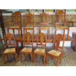 An oak French made dining table with two additional leaves and eight rush seated chairs including