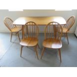 An Ercol blonde elm dining table with four stick back chairs - Table 71cm tall x 152cm, Chairs