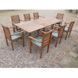 A teak extending garden table with eight chairs and cushions - as new