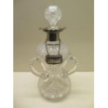 A triform cut glass decanter with a silver rim/pourer and a silver sherry label - Height 26cm - good