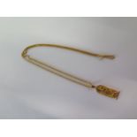 An Egyptian 18ct gold pendant on a 9ct 50cm chain - total weight approx 11.2 grams - pendant 4.2