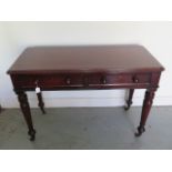 A Victorian mahogany side table with two frieze drawers tapering and turned legs with brass caps and