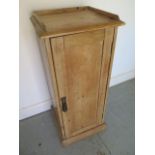 A stripped pine single door cupboard with a shelved interior - Height 92cm x 40cm x 36cm