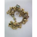 A 9ct yellow gold charm bracelet with 35 assorted charms - approx total weight 76 grams