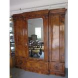 A good quality mid Victorian burr walnut breakfront wardrobe with a central mirrored door flanked by