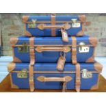 A set of three blue canvas and tan leather graduating suitcases by Papworth Luggage with brass